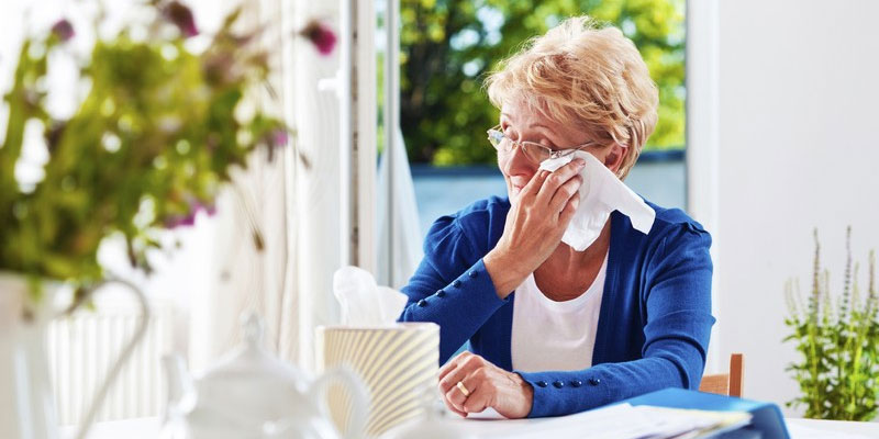 older lady wiping her tears with a tissue